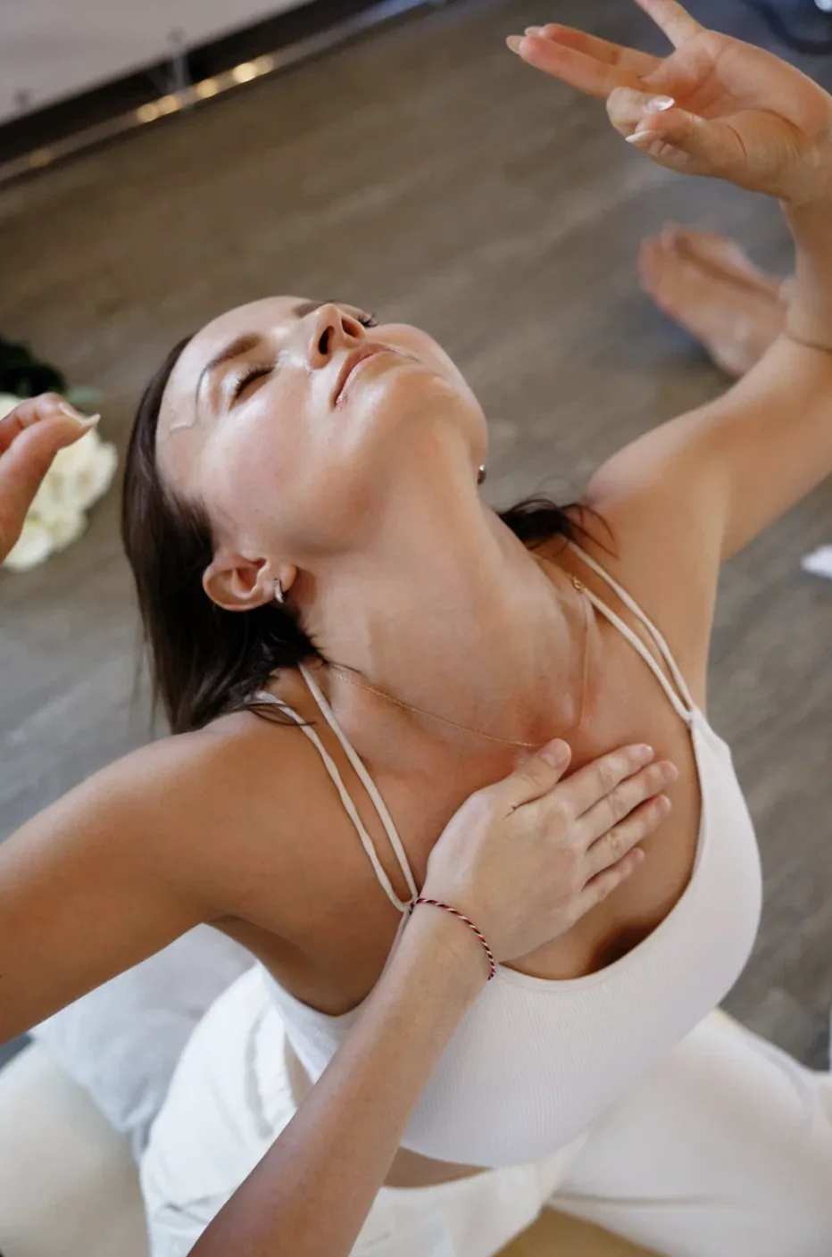 A participant sitting with her head tilted back and a hand on her heart