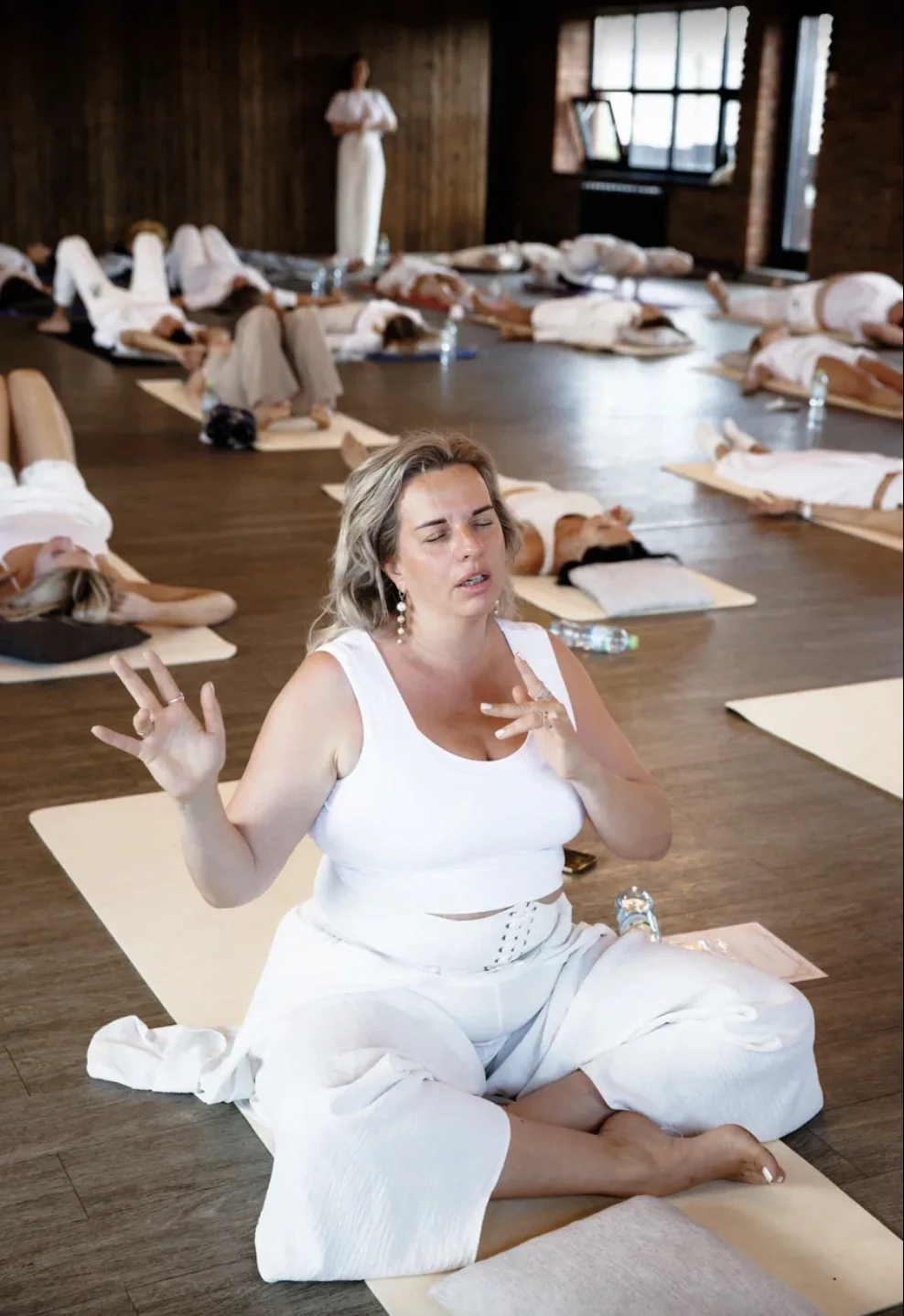 Alina facilitating among participants lying on mats during a group session
