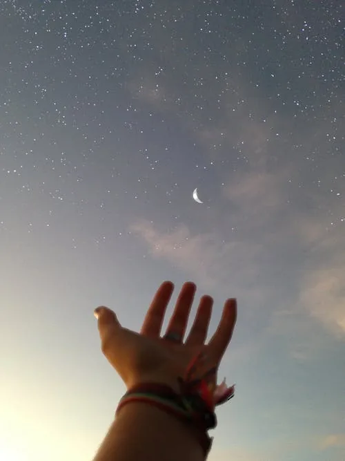 hand at the starry sky. stargazing as a form of mindfulness meditation