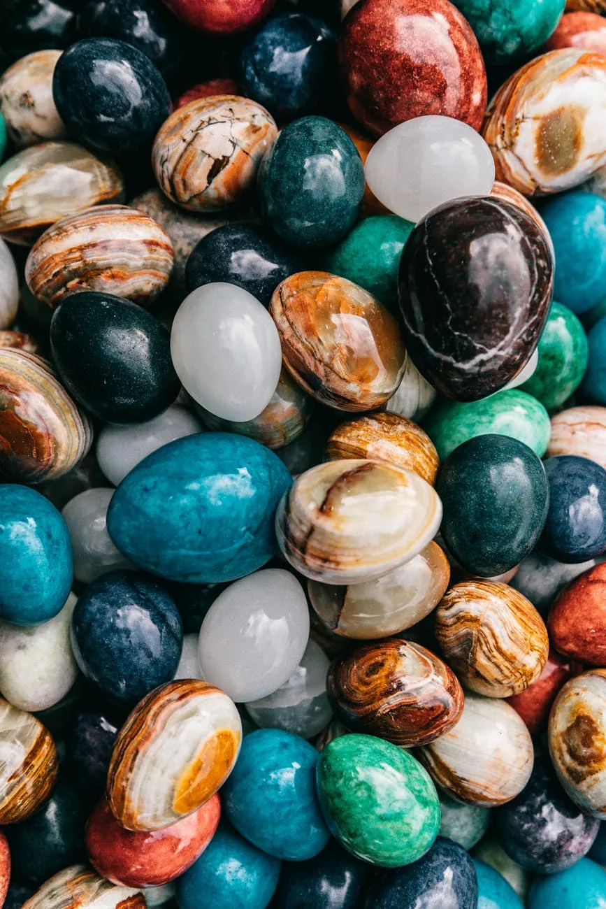 Abundance of colorful egg-shaped natural stones and healing crystals