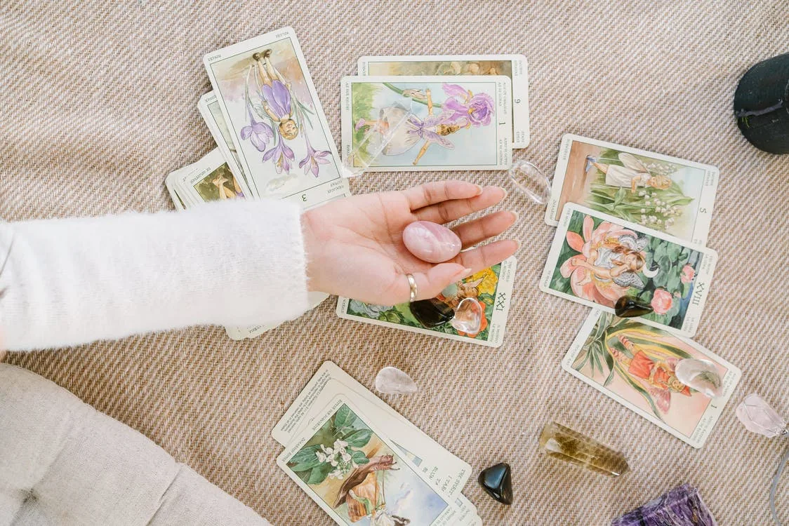 Palm open with rose quartz crystal. Tarot cards meditation with crystals. Spiritual awakening. 